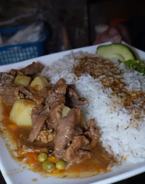 Plato de carne guisada con arroz, papa y arvejas en Agachaditos del INTER